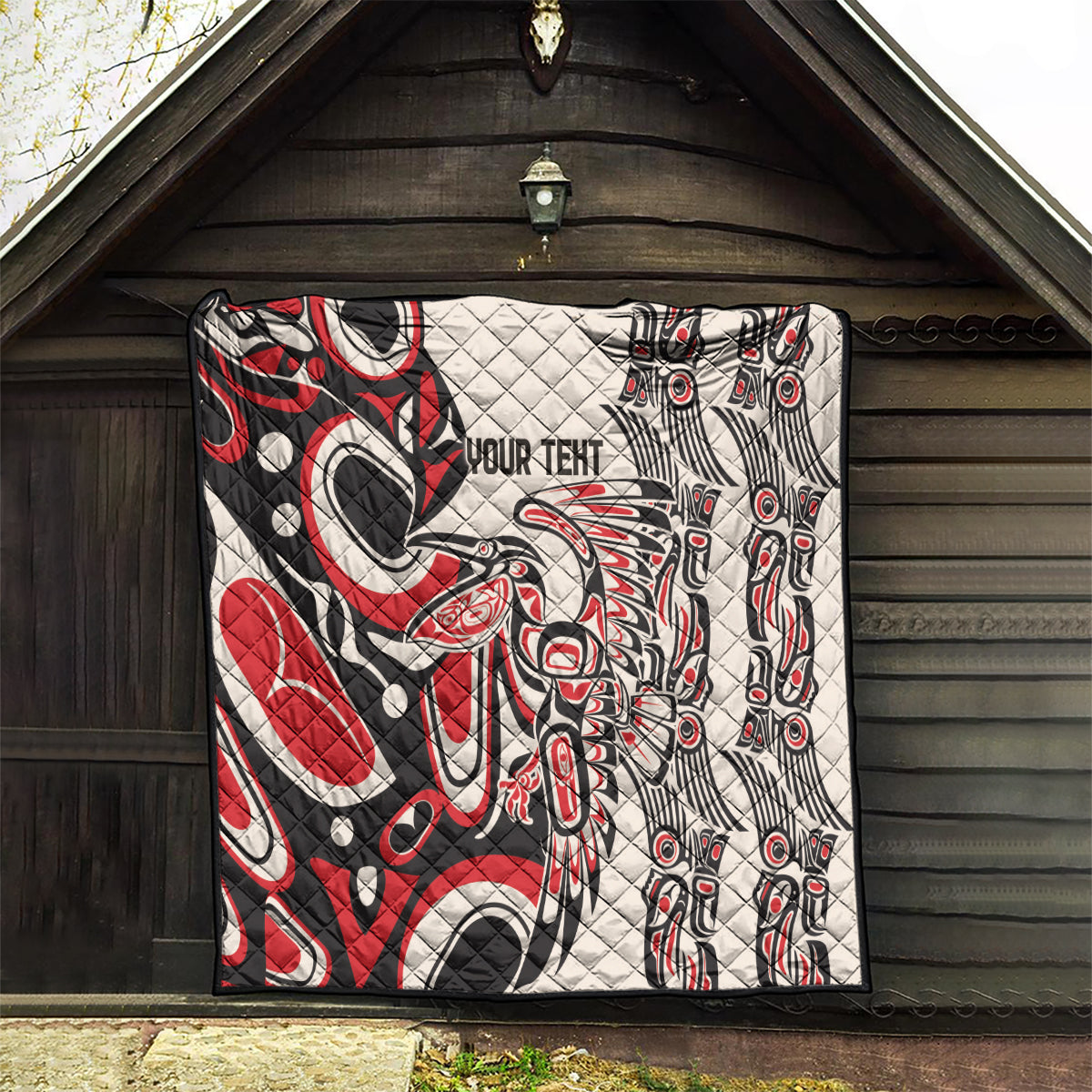 Personalized quilt in red, black, and white with “YOUR TEXT” and tribal eye-and-feather pattern