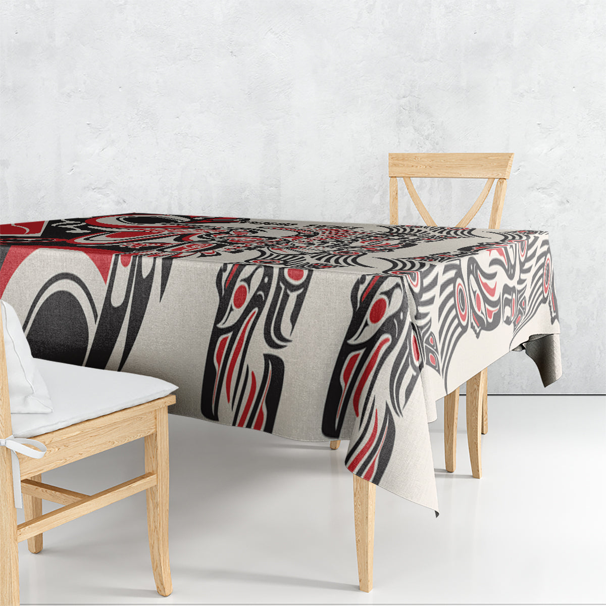 Red and black tablecloth with white abstract tribal pattern, draped on a small table.