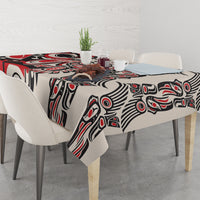 Tablecloth with red, black, and white tribal-style pattern, covering a dining table.