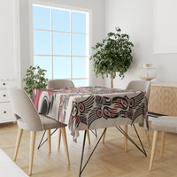 Rectangular tablecloth with bold red, black, and white abstract pattern on a dining set.