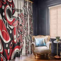Red, black, and white tribal patterned window curtain panels with chair nearby