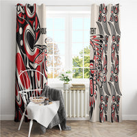 Two red, black, and white tribal patterned window curtains framing a window
