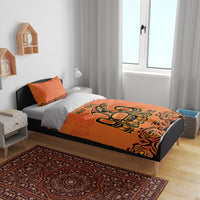 Orange duvet bedding set with large Haida-style animal graphic on bed, two pillowcases