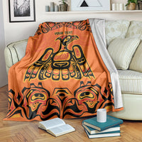 Orange patterned throw blanket with 'YOUR TEXT' and large Haida bird and totem design