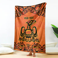 Orange patterned throw blanket with 'YOUR TEXT' and Haida bird and totem illustration