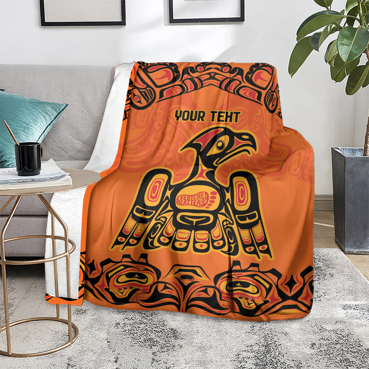 Orange patterned throw blanket with 'YOUR TEXT' and Haida bird and swirling border