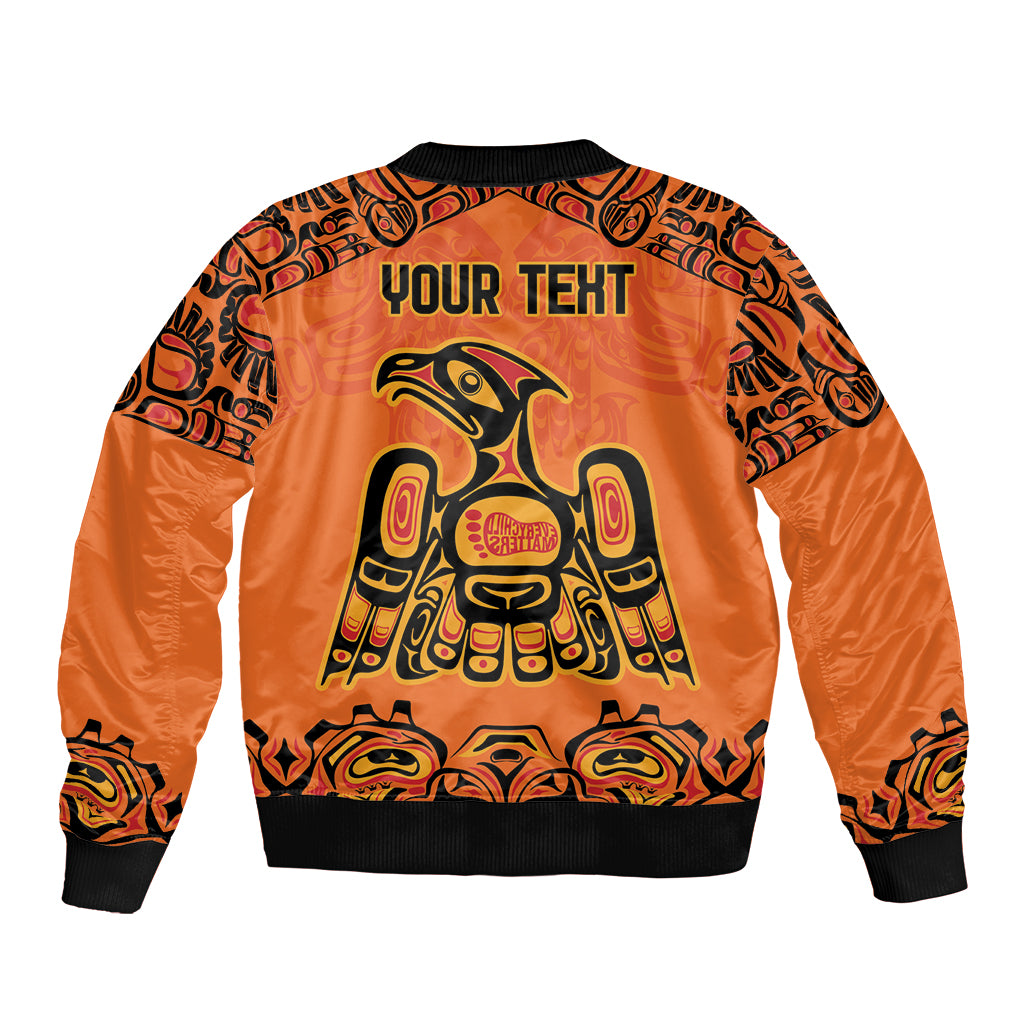 Orange bomber jacket back with black ribbing, YOUR TEXT, and Haida-style eagle artwork