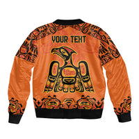 Orange bomber jacket back with black ribbing, YOUR TEXT, and Haida-style eagle artwork