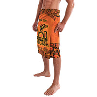 Orange board shorts with black pattern panels and bird motif, mid-thigh length, elastic waistband.