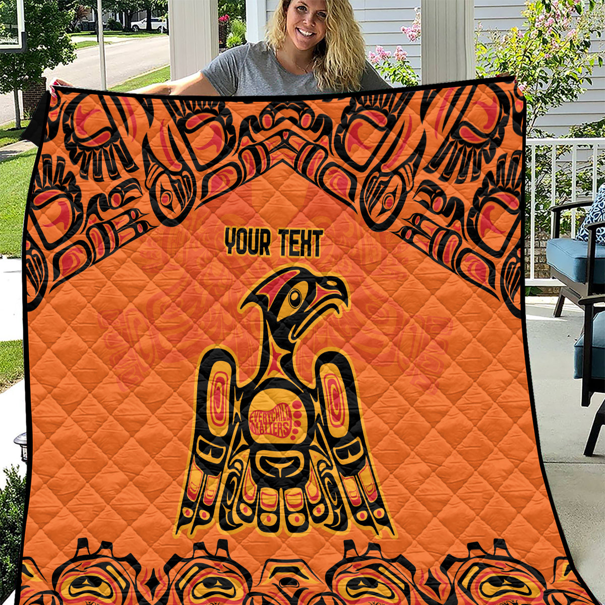 Orange quilt blanket with black border, Haida-style raven figure and "YOUR TENT" text