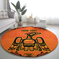 Round orange patterned rug with eagle/Haida-style figure and 'YOUR TEXT' title