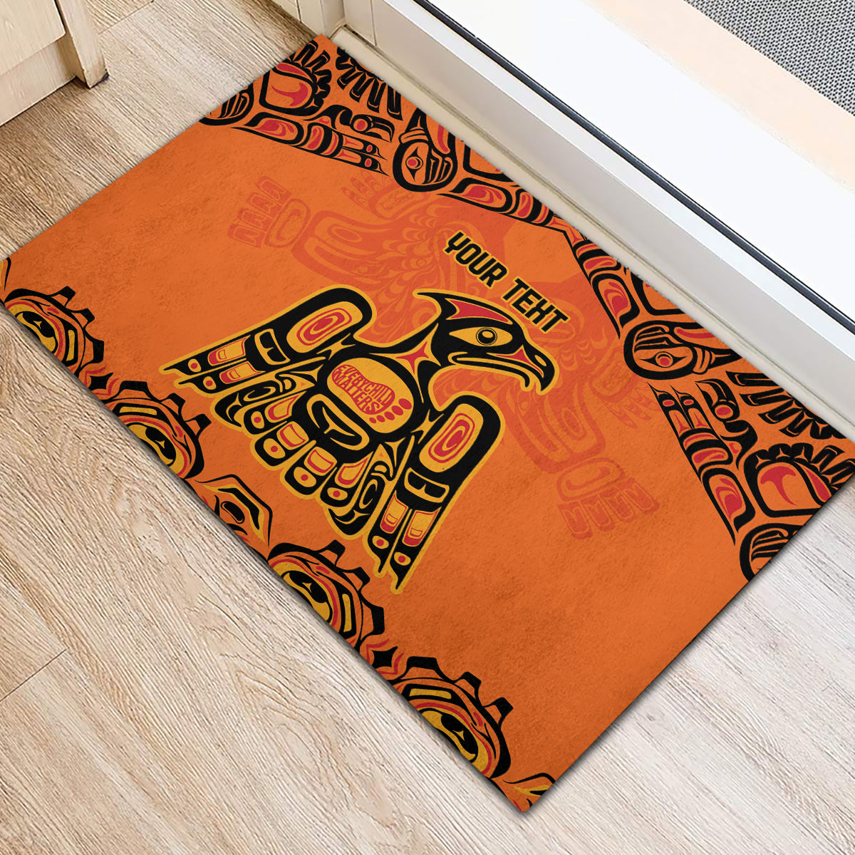 Orange rubber doormat showing 'YOUR TEHT' and central totem-style figure in black