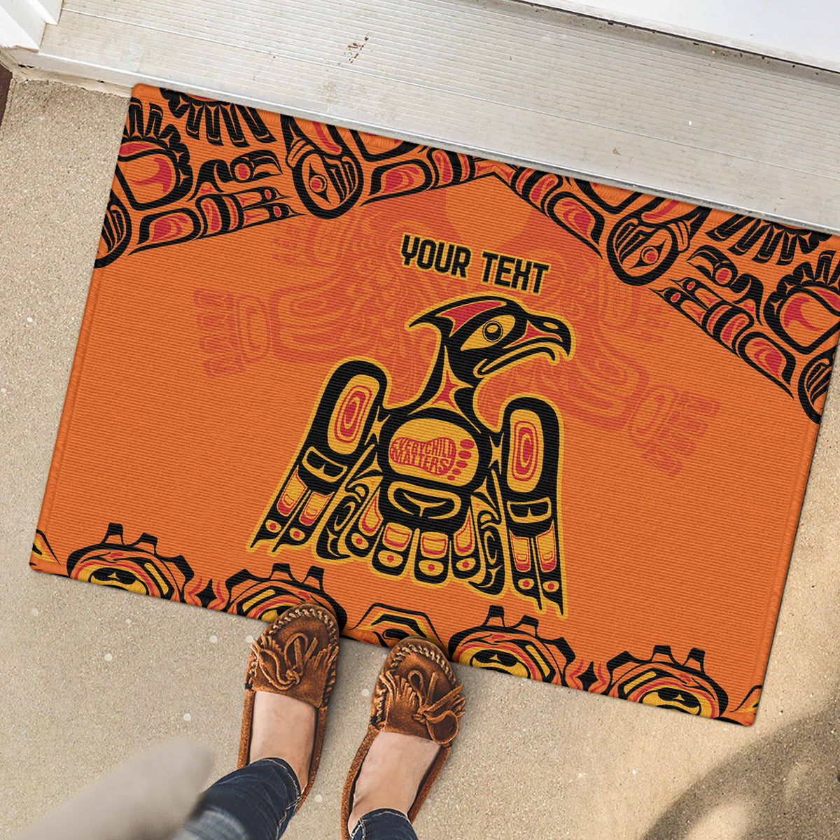 Orange rubber doormat with 'YOUR TEHT' and tribal patterned border in black