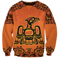 Unisex orange sweatshirt with Haida-style totem bird graphic and decorative sleeves