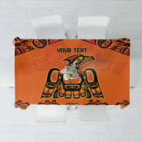 Orange tablecloth with black tribal-style motif and central emblem, rectangular view