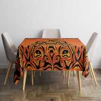 Orange tablecloth with black tribal pattern, neatly spread on dining table