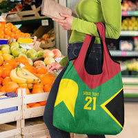 Reusable grocery bag held at produce market, green red yellow black tent design