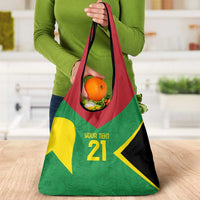 Reusable grocery bag with tent design, held by person; green red yellow and black