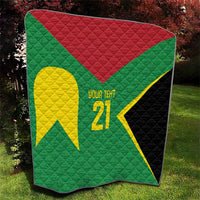 Folded green quilt featuring large yellow emblem, '21', red triangle, and black side