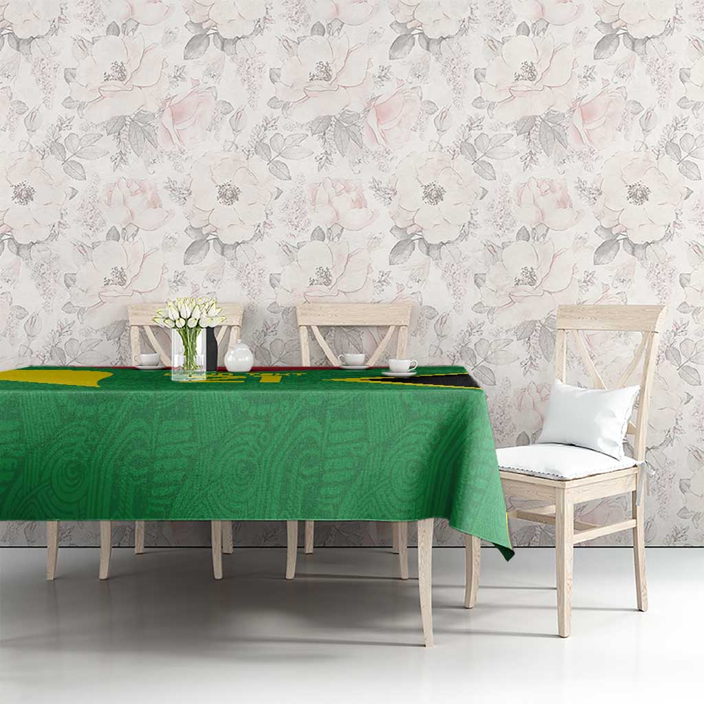 Green custom tablecloth with gold and black accents on long dining table