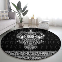 Black round area rug featuring ornate Viking-style emblem and border braid