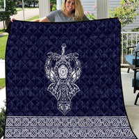 Blue quilt with quilted pattern and white Viking axe emblem, patterned border