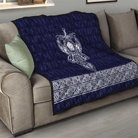 Blue quilt draped over sofa with white Viking axe emblem and ornate border strip
