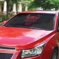 Car windshield sun shade on red vehicle, black with red Viking emblem and runes