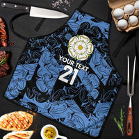 Custom apron laid flat with blue swirls; floral badge, 'YOUR TEXT' and 21 print