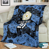 Personalized fleece blanket in blue and navy with flower emblem, 'YOUR TEXT' and 21, draped over chair