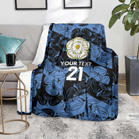 Personalized fleece blanket in blue and navy with flower emblem, 'YOUR TEXT' and 21, draped on sofa