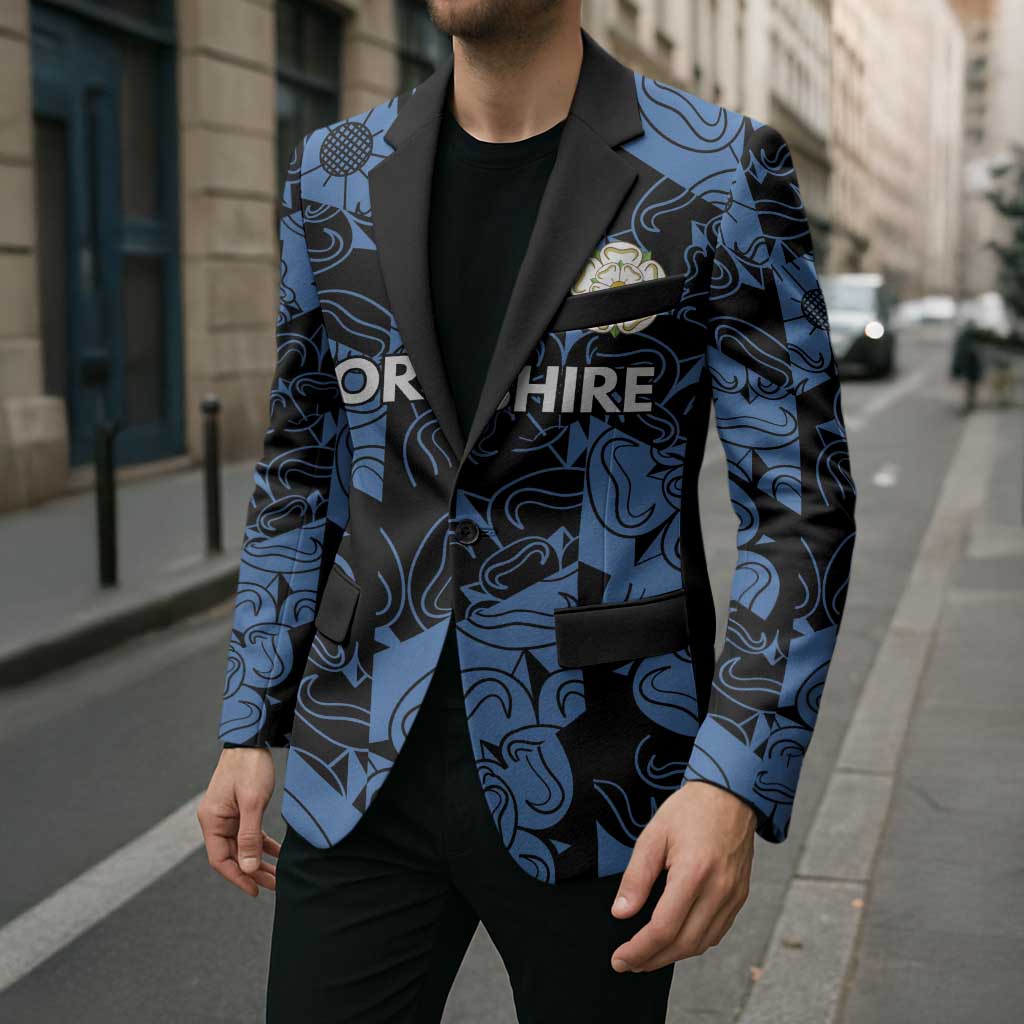 Unisex blazer with blue-and-black pattern, black lapels and pocket trim, angled front view