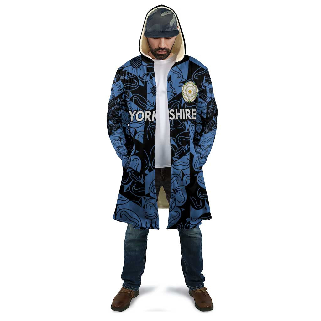Hooded cloak with blue-and-black swirls, front zipper, crest patch on chest