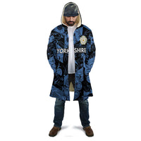 Hooded cloak with blue-and-black swirls, front zipper, crest patch on chest