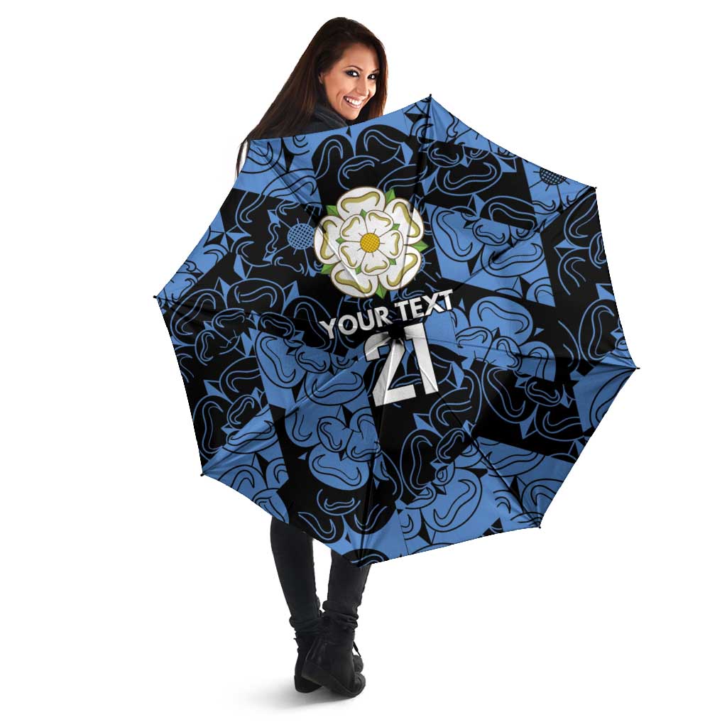 Blue patterned custom umbrella with rose emblem and “YOUR TEXT 21” in angled view