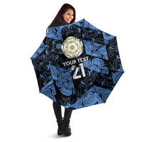 Blue patterned custom umbrella with rose emblem and “YOUR TEXT 21” in angled view