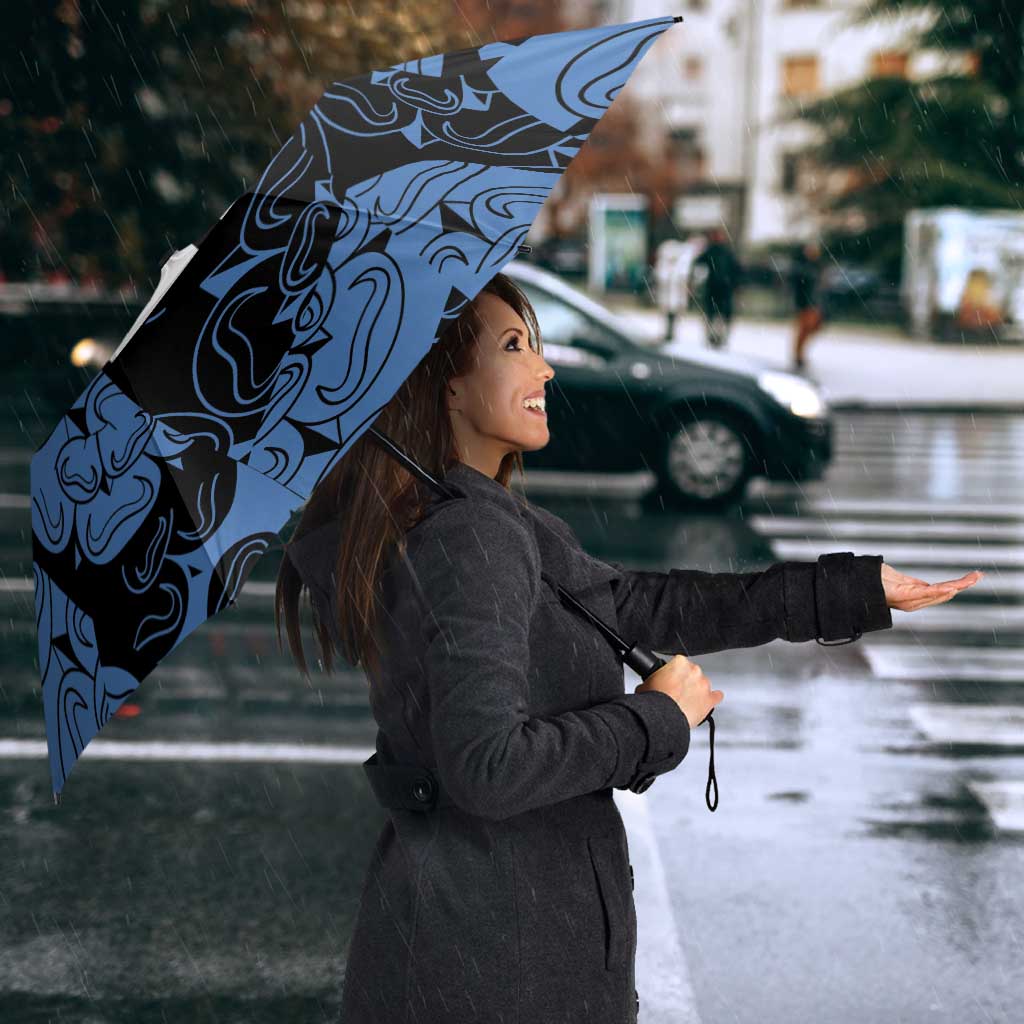 Blue patterned custom umbrella with rose emblem, held open in the rain
