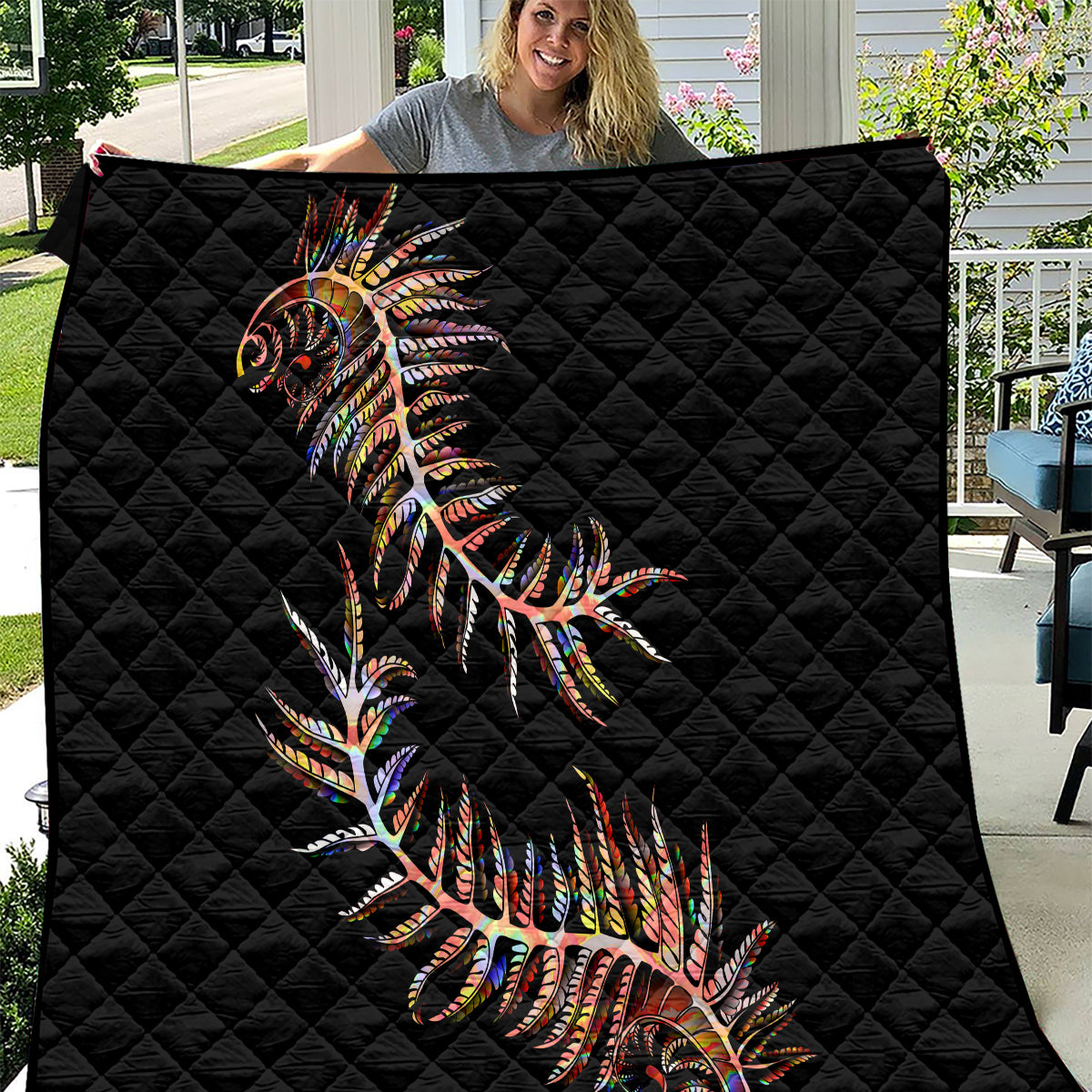 Black quilt with colorful fern-style artwork, diamond quilted pattern