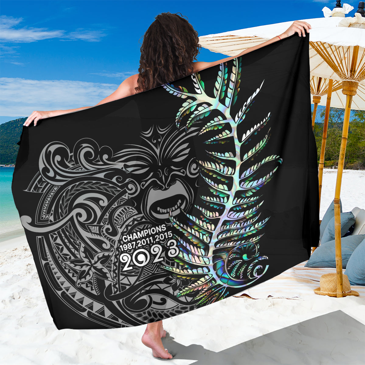 Black sarong with ornate silver and teal fern feather graphic and 2023 text