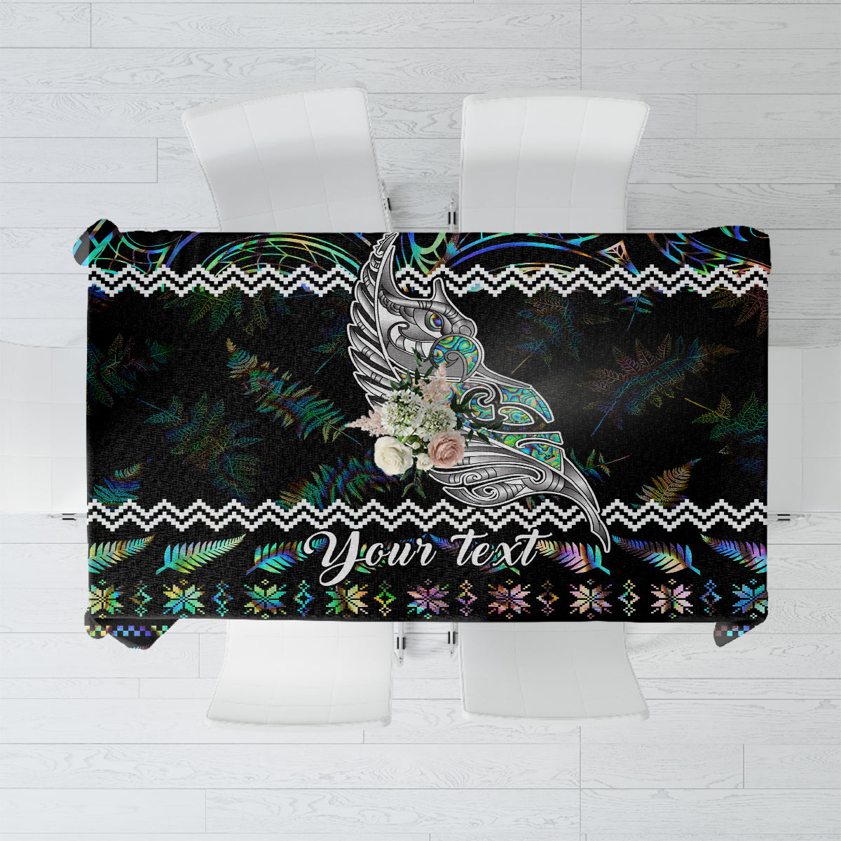 Personalised black tablecloth with colorful Maori fern and wing motif, ‘Your text’ banner