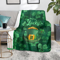 Green throw blanket featuring shamrock clover pattern and 'Feeling Lucky' centerpiece