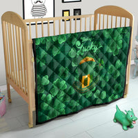 Green clover quilt in a crib with 'Feeling Lucky' text and gold pot print