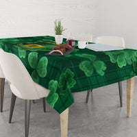 Green tablecloth with clover shamrock and plaid design across tabletop