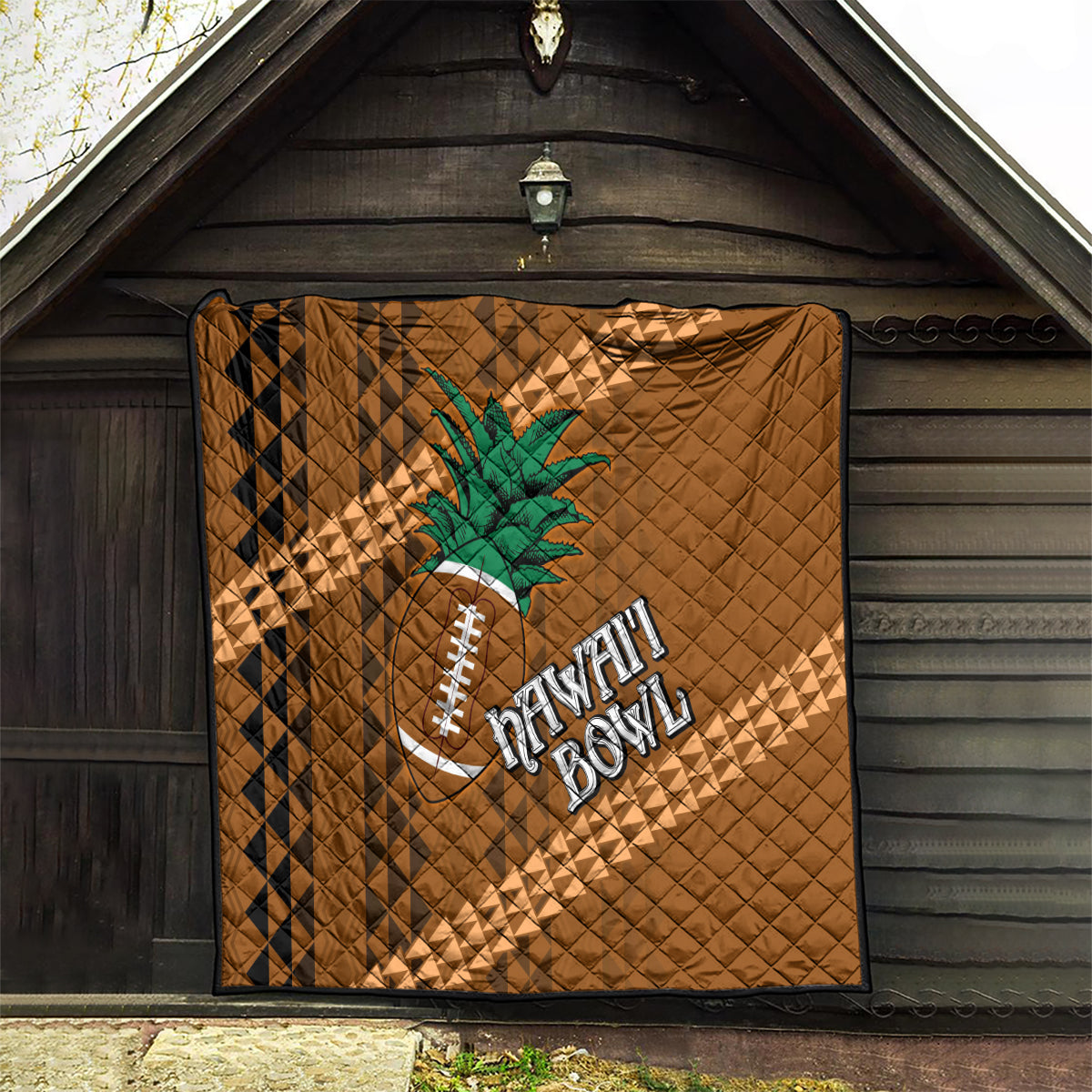 Brown quilt with tribal diamond pattern, palm tree and football graphic hanging