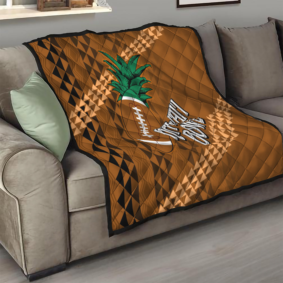 Brown quilt with tribal diamond pattern, green palm tree and football logo on couch