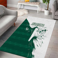 Green and white area rug with bold falcon head illustration and Arabic-style script