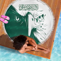 Round green-and-white beach blanket with Saudi falcon print, tassel edge