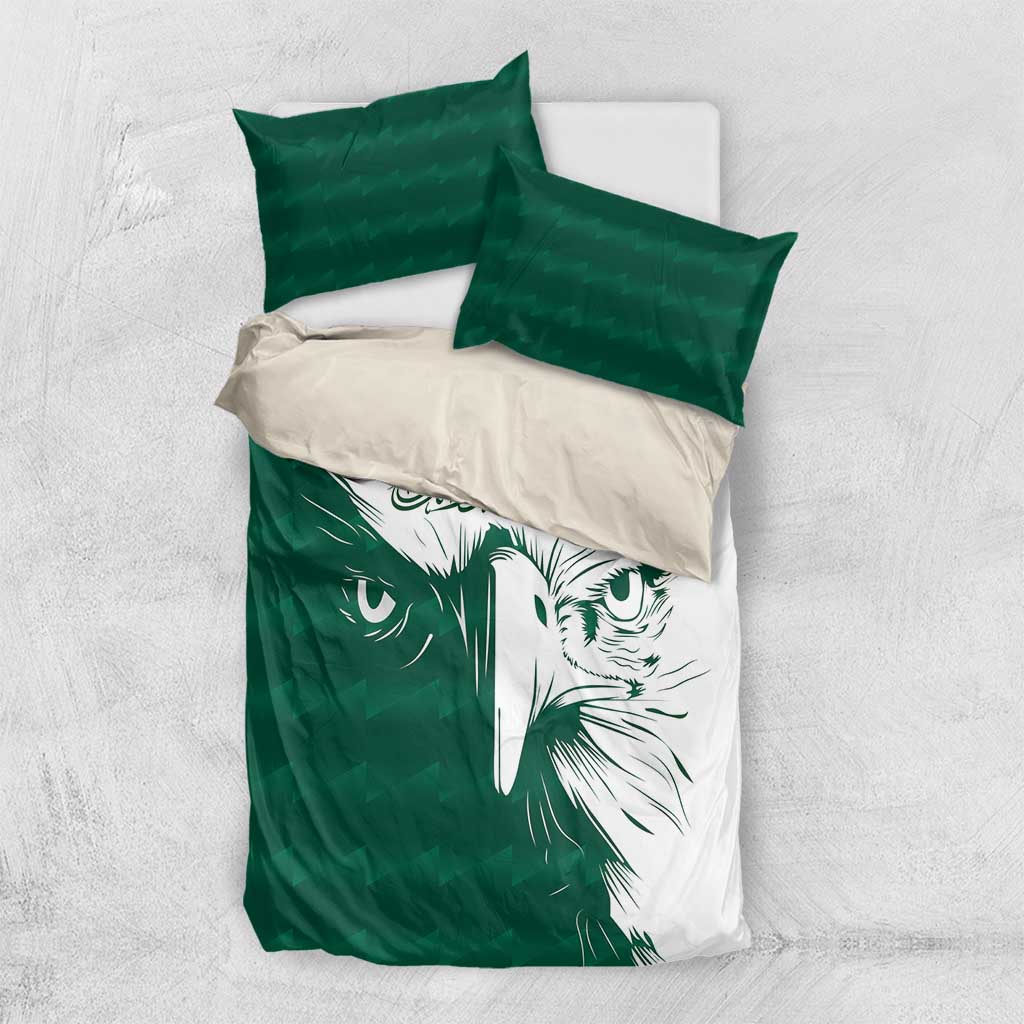Green and white bedding set with falcon face print and two green pillows on top