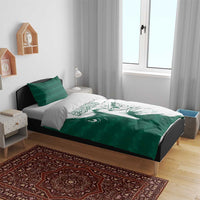 Green and white duvet cover set with falcon face design and two green pillows on bed