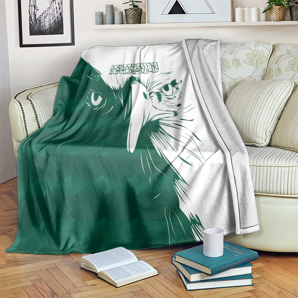Green and white falcon pattern blanket draped on a sofa with books nearby